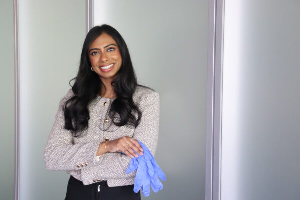Navisha Weersinghe holding a pair of blue medical gloves